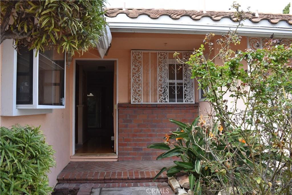 entrance to property with brick siding and stucco siding