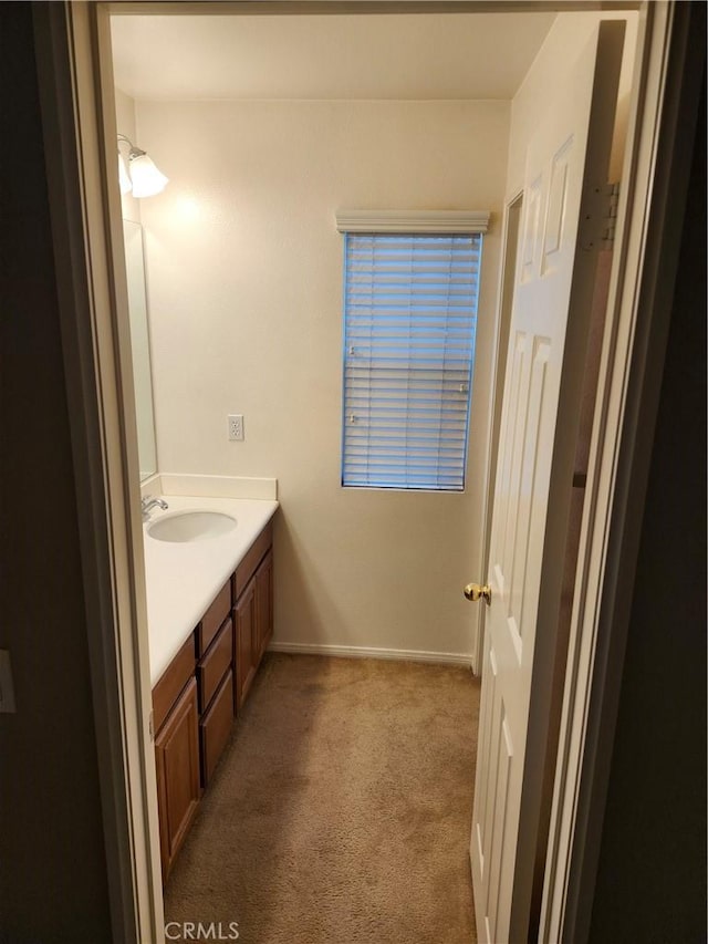 bathroom featuring carpet floors, baseboards, and vanity