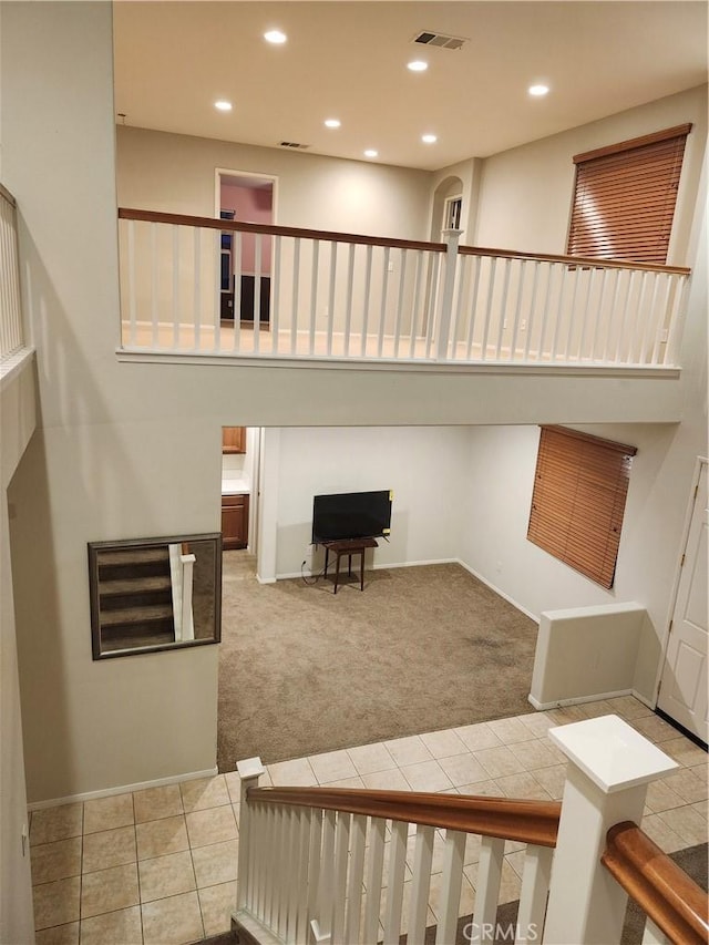 stairs with visible vents, recessed lighting, carpet floors, tile patterned floors, and baseboards