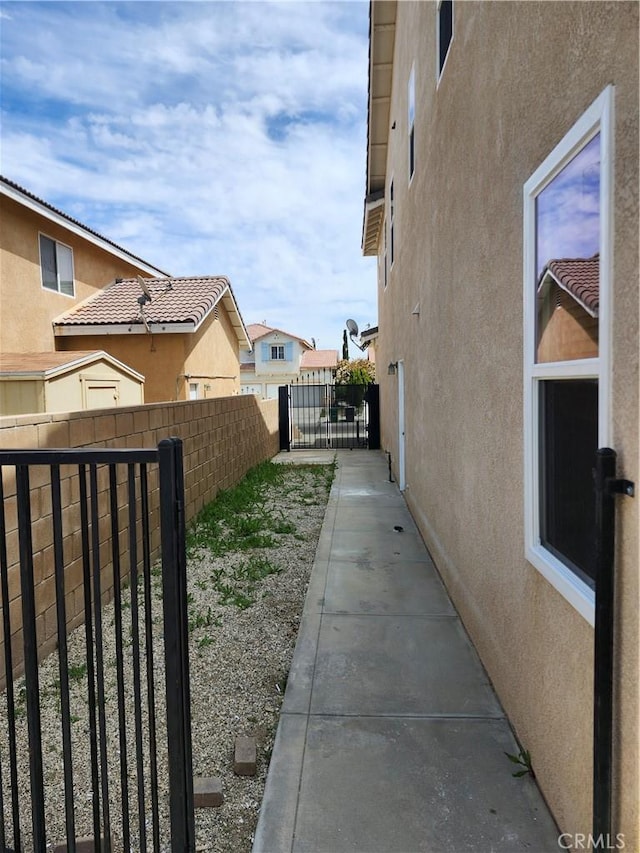 view of side of property with a fenced backyard, stucco siding, and a residential view