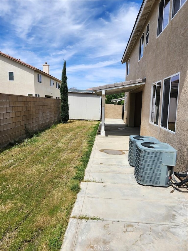 view of yard with central AC, a fenced backyard, and a patio area