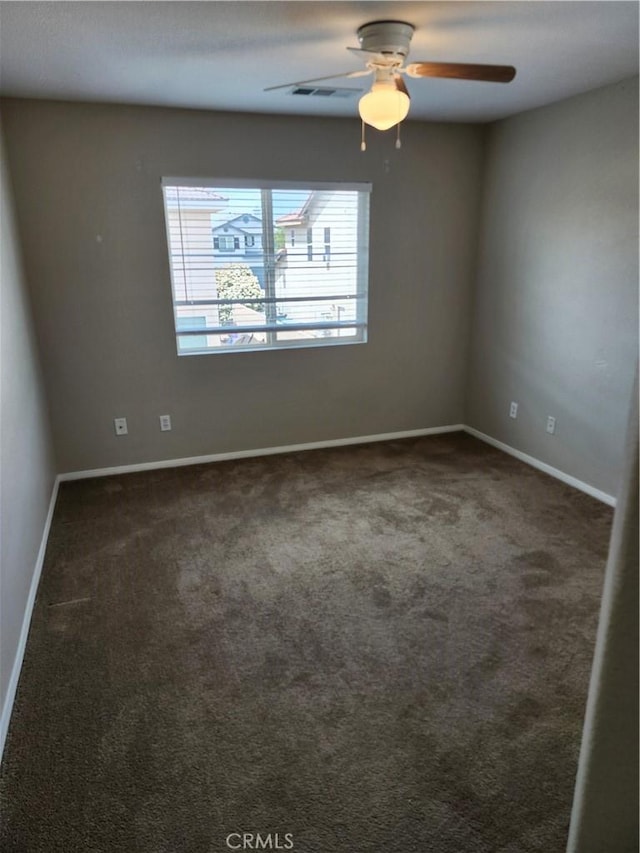 empty room featuring carpet, baseboards, and ceiling fan