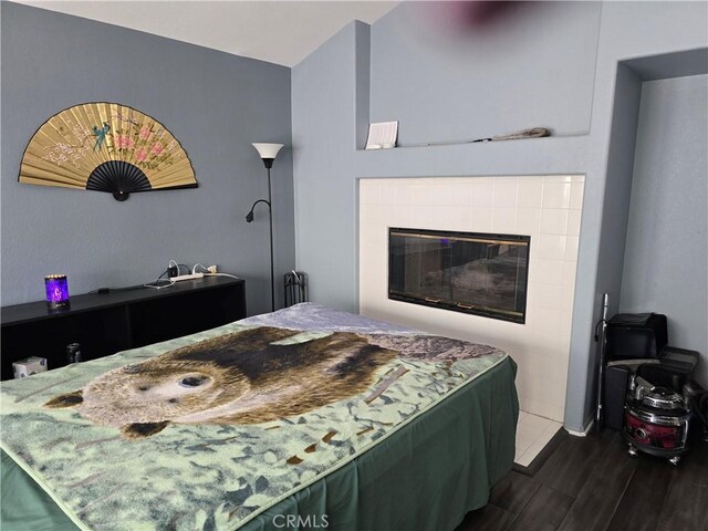 2 Wellesley Ct, Coto De Caza, CA 92679 - bedroom featuring dark wood-style flooring and a tile fireplace