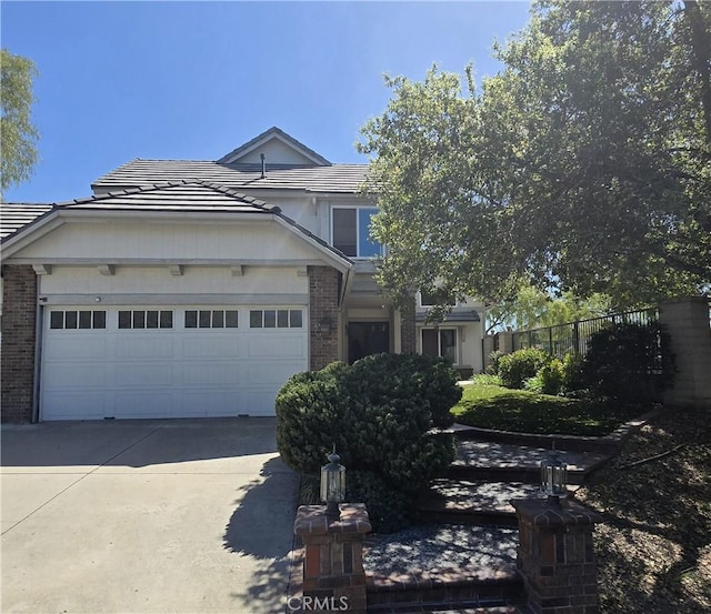 2 Wellesley Ct, Coto De Caza, CA 92679 - view of front of home featuring brick siding, driveway, a tiled roof, and fence