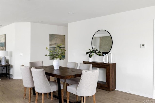 dining room with light wood-style floors and baseboards