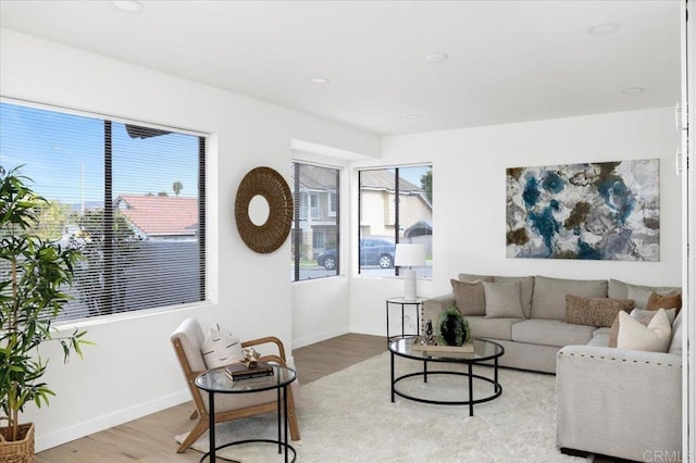 living area featuring recessed lighting, light wood-type flooring, and baseboards