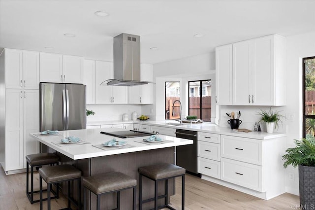 kitchen featuring black appliances, island exhaust hood, a sink, a center island, and a breakfast bar area