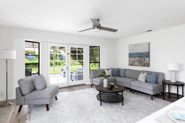 living area with visible vents, french doors, light wood-type flooring, and a ceiling fan