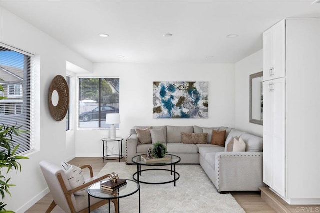 living room featuring recessed lighting, baseboards, and light wood-style floors