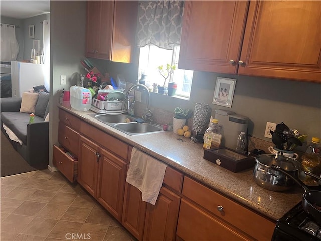 kitchen with a sink, brown cabinetry, and light tile patterned floors