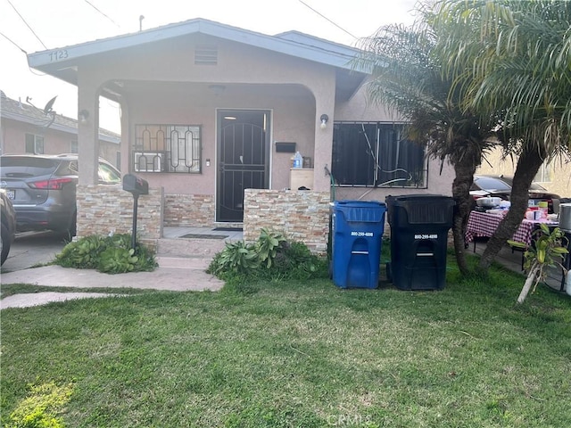 view of front facade with stucco siding and a front lawn