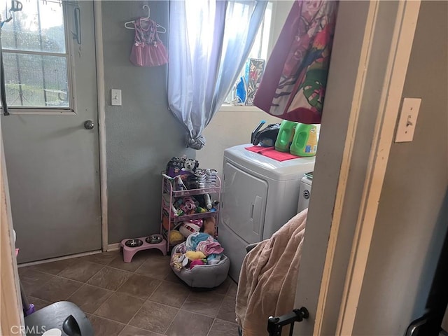 clothes washing area featuring laundry area, dark tile patterned flooring, and separate washer and dryer