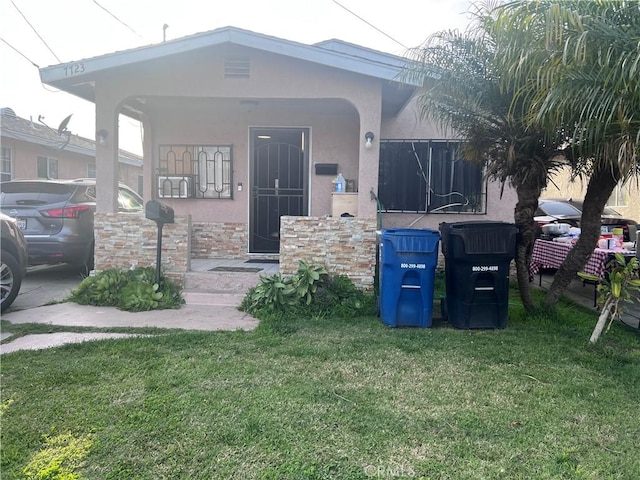 view of front of home with a front yard and stucco siding