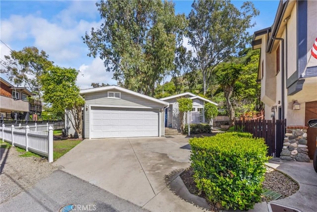 garage with driveway and fence