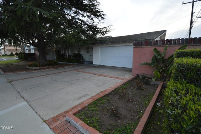view of front of property with concrete driveway, fence, and a garage