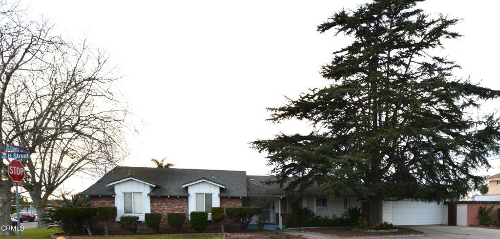 view of front of house with brick siding, driveway, an attached garage, and roof with shingles
