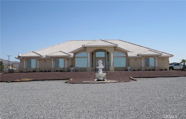 mediterranean / spanish-style house with stucco siding and a tiled roof