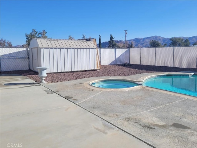 view of pool featuring a fenced backyard, a mountain view, a fenced in pool, an in ground hot tub, and a patio area