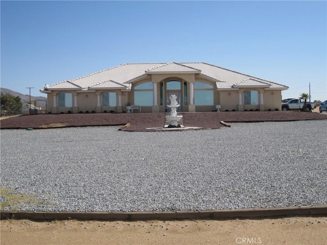 view of front facade with stucco siding and a tile roof