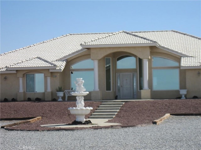 view of front of house with stucco siding and a tiled roof