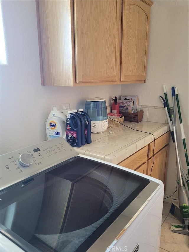 washroom with washer and clothes dryer and cabinet space