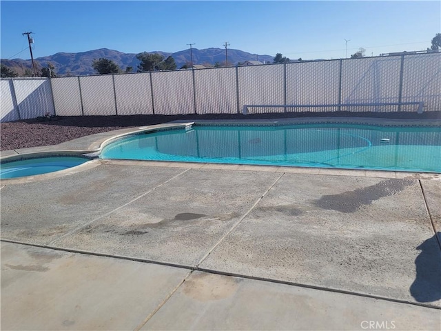 view of pool featuring a mountain view, a fenced in pool, an in ground hot tub, and fence