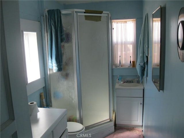 full bath featuring toilet, a stall shower, and vanity