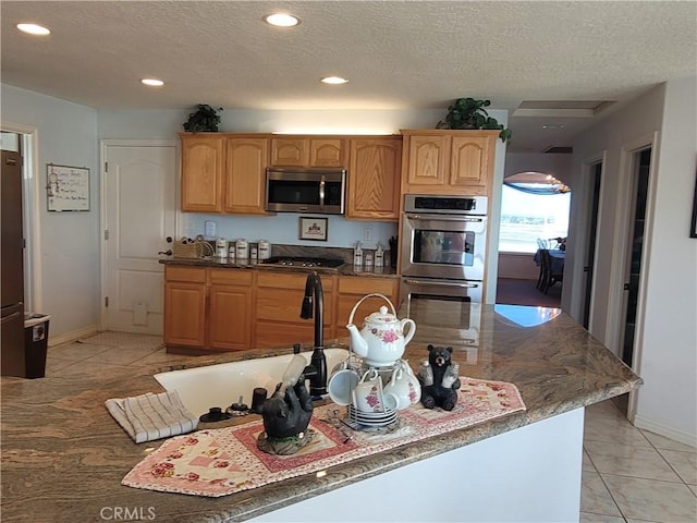 kitchen with recessed lighting, a textured ceiling, and appliances with stainless steel finishes