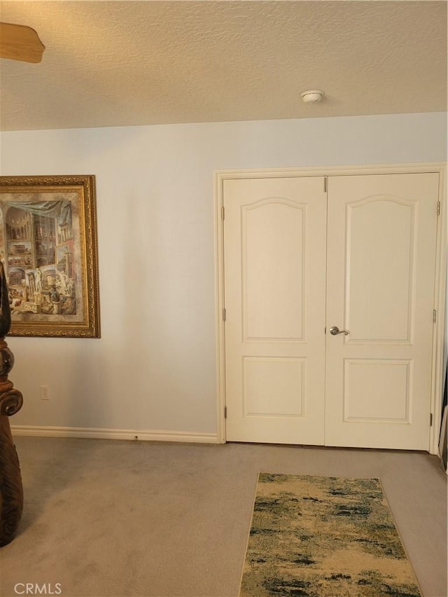 interior space with a textured ceiling and baseboards