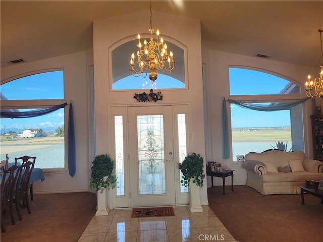 entryway featuring light tile patterned flooring, a notable chandelier, a high ceiling, and visible vents