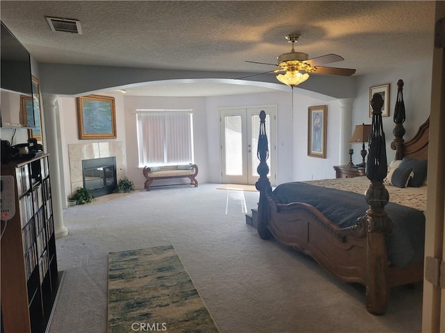 carpeted bedroom with visible vents, a fireplace, arched walkways, access to exterior, and french doors