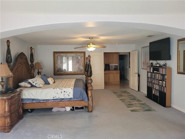 bedroom with arched walkways, light carpet, and a ceiling fan