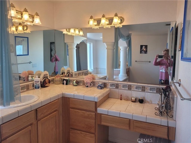 full bath with decorative columns and vanity