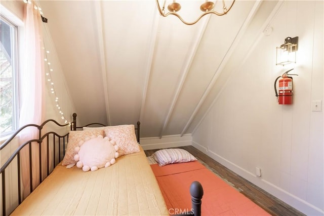 bedroom with baseboards, lofted ceiling, and wood finished floors