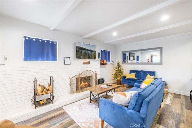 living room with beamed ceiling, baseboards, wood finished floors, and a fireplace