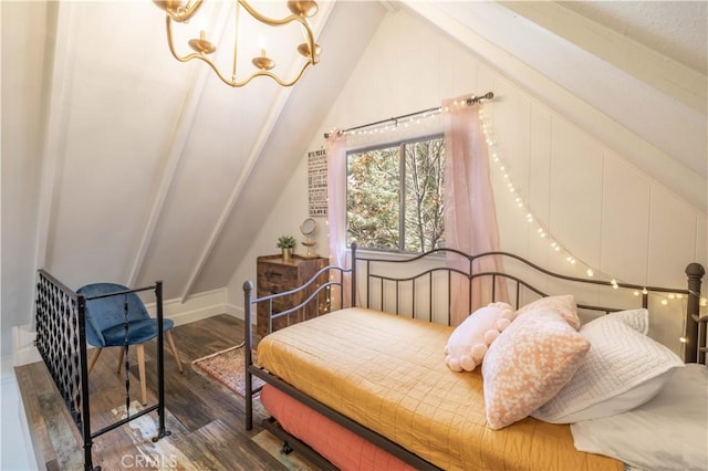 bedroom with lofted ceiling, a decorative wall, wood finished floors, and a chandelier