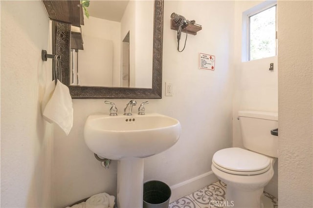 bathroom featuring toilet and baseboards