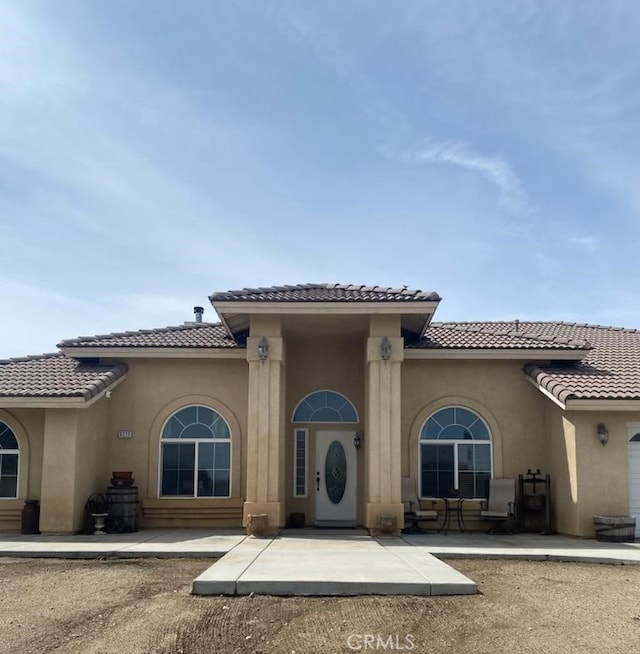 doorway to property with a tiled roof and stucco siding