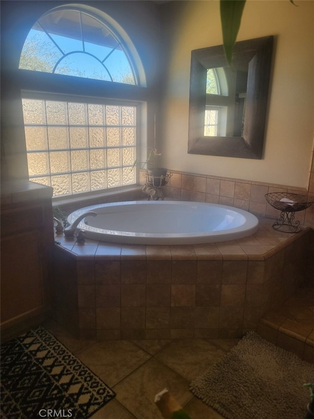 full bath featuring tile patterned floors, plenty of natural light, and a bath