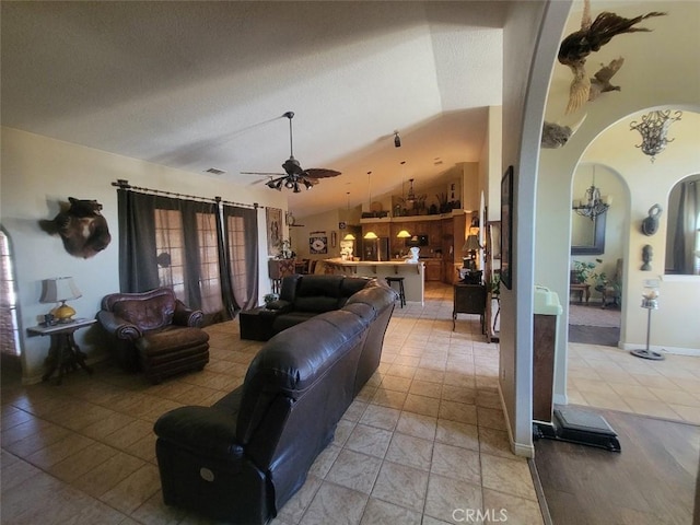 living room featuring lofted ceiling, arched walkways, and a ceiling fan