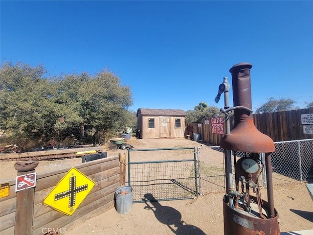 view of front of house with fence, a gate, an outbuilding, and a storage unit