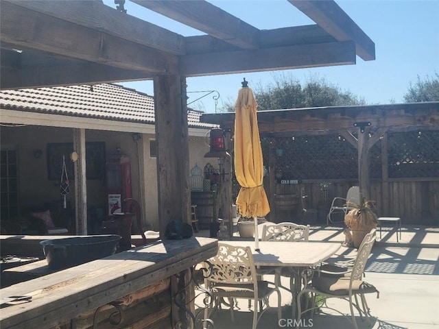 view of patio / terrace featuring outdoor dining area, fence, and a pergola
