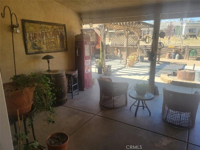 view of patio / terrace featuring a bar and fence