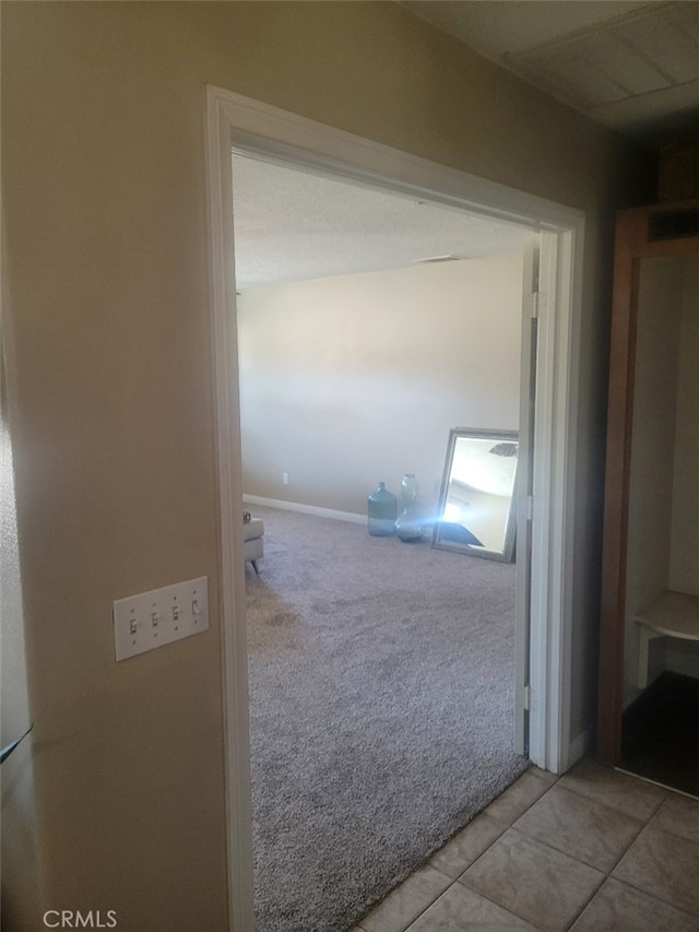 hallway featuring carpet and tile patterned flooring