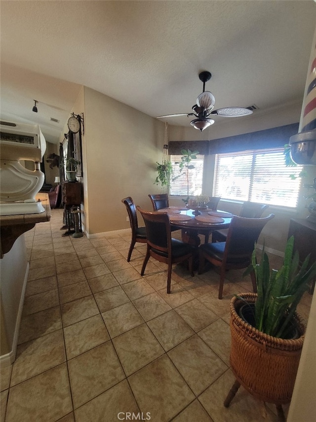 dining space with tile patterned floors, baseboards, and a textured ceiling