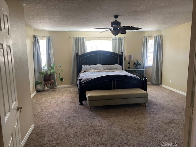 bedroom featuring multiple windows, light carpet, a textured ceiling, a ceiling fan, and baseboards