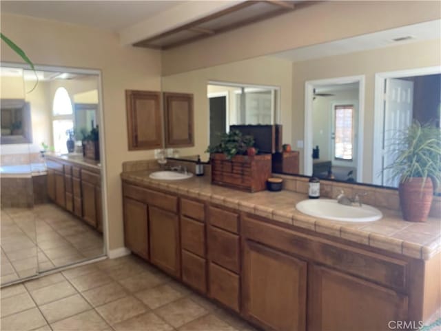 bathroom with tile patterned flooring, double vanity, ceiling fan, and a bath