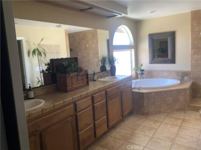 full bathroom with a garden tub, double vanity, and tile patterned flooring