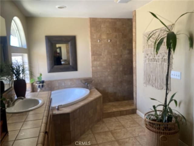 bathroom featuring a garden tub, vanity, a walk in shower, tile patterned floors, and baseboards