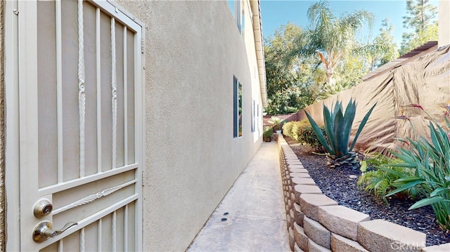 view of home's exterior with stucco siding and fence
